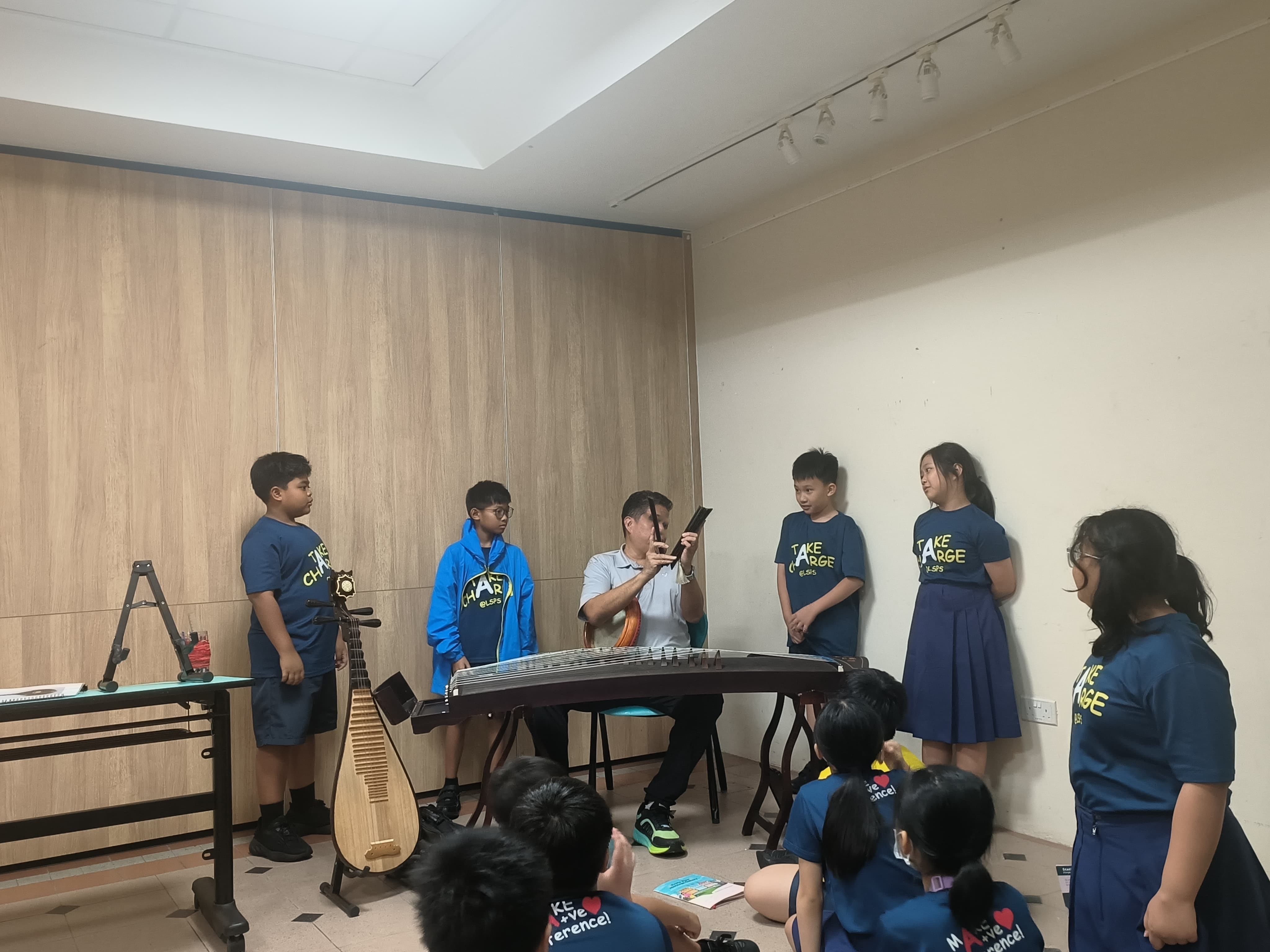 Students gathered around to learn about a musical art form, Nanyin.